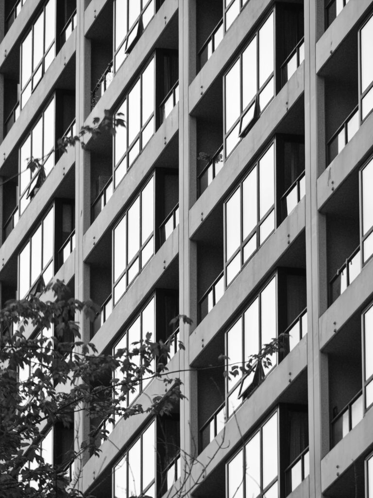 Modern Building Facade with Geometric Windows & Tree Branches Wallpaper