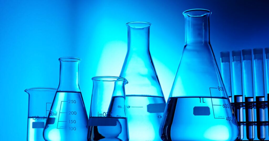 Chemistry wallpaper with blue background featuring beakers flasks and test tubes for science