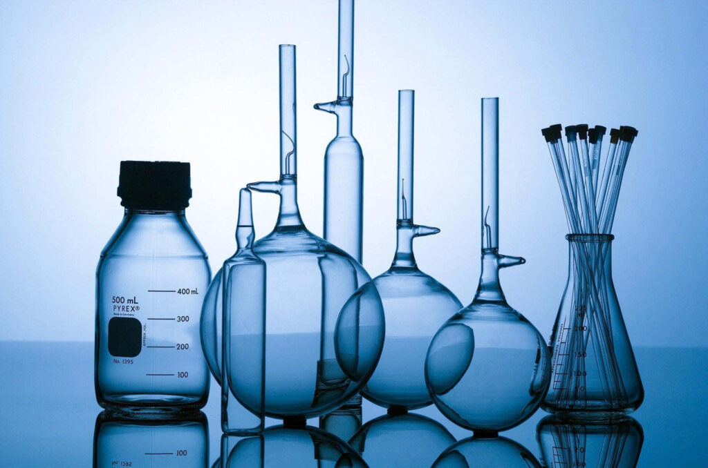 Transparent chemistry glassware including beakers flasks and test tubes on blue gradient background Wallpaper
