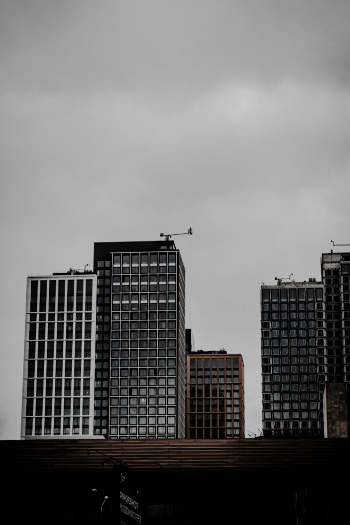 Modern Cityscape Wallpaper: Sleek Buildings & Moody Sky Background