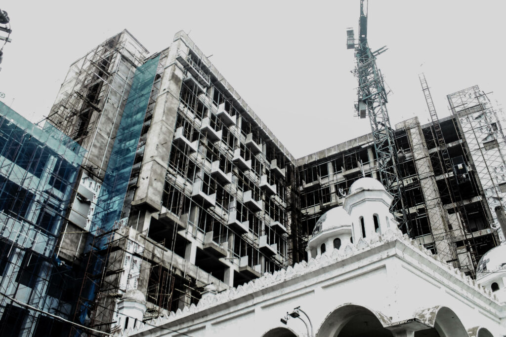 Concrete building under construction with scaffolding cranes highlighting modern architecture Wallpaper