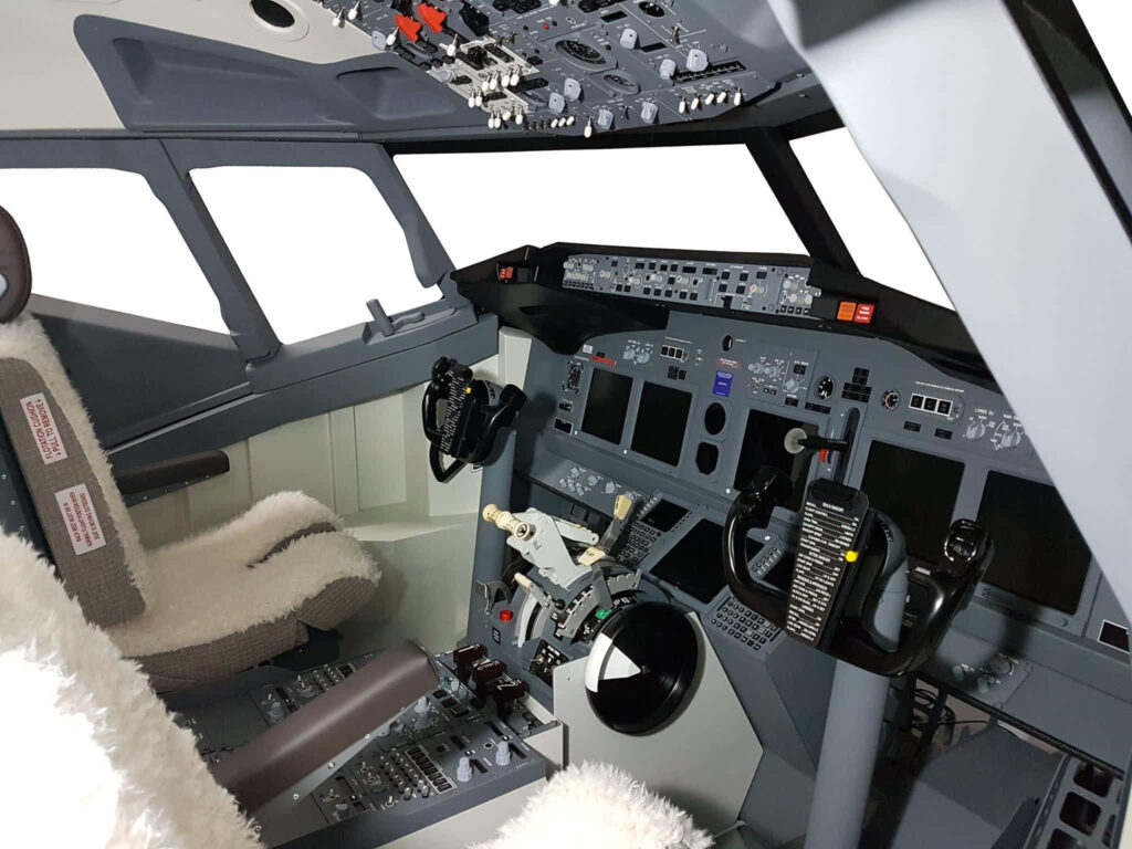 Detailed commercial airplane cockpit interior with advanced controls and pilot seats in grayscale Wallpaper
