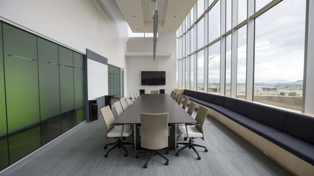 Modern conference room with dark table neutral chairs bright natural light for Zoom background Wallpaper