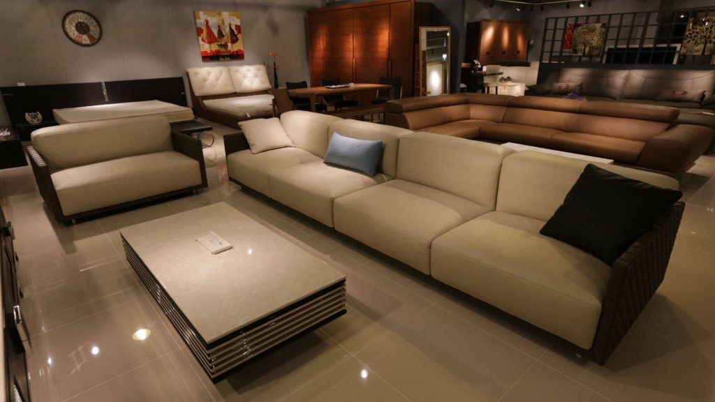 Contemporary cream modular sofa and low-profile coffee table in minimalist upscale living room showroom Wallpaper