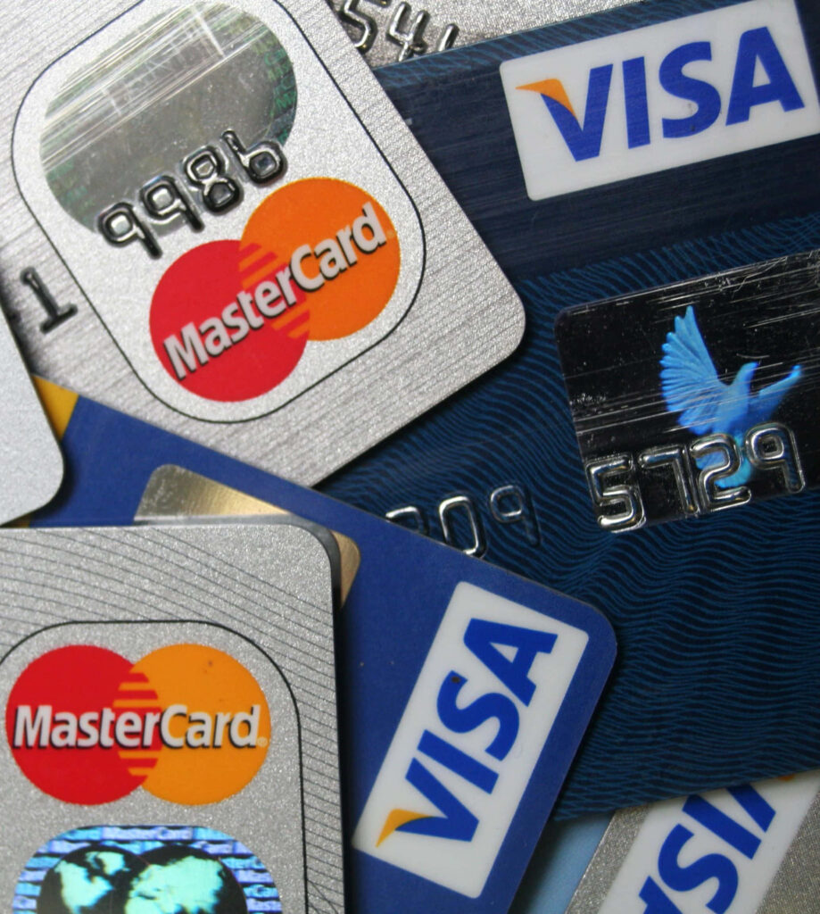Close-up of modern Visa and MasterCard credit cards with metallic embossed design on wood background Wallpaper