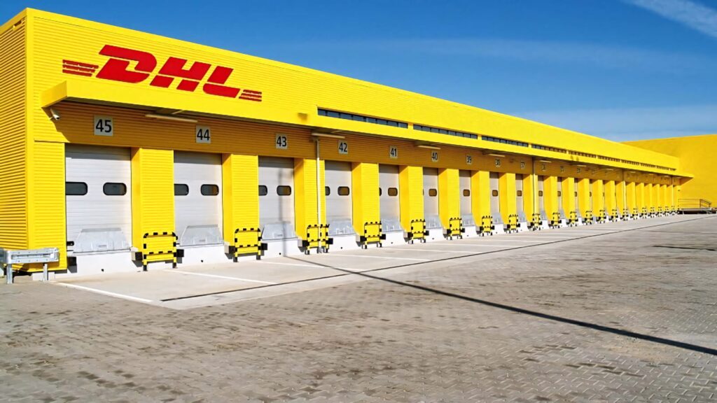 Vibrant DHL distribution center with bright yellow docks under clear blue sky logistics wallpaper