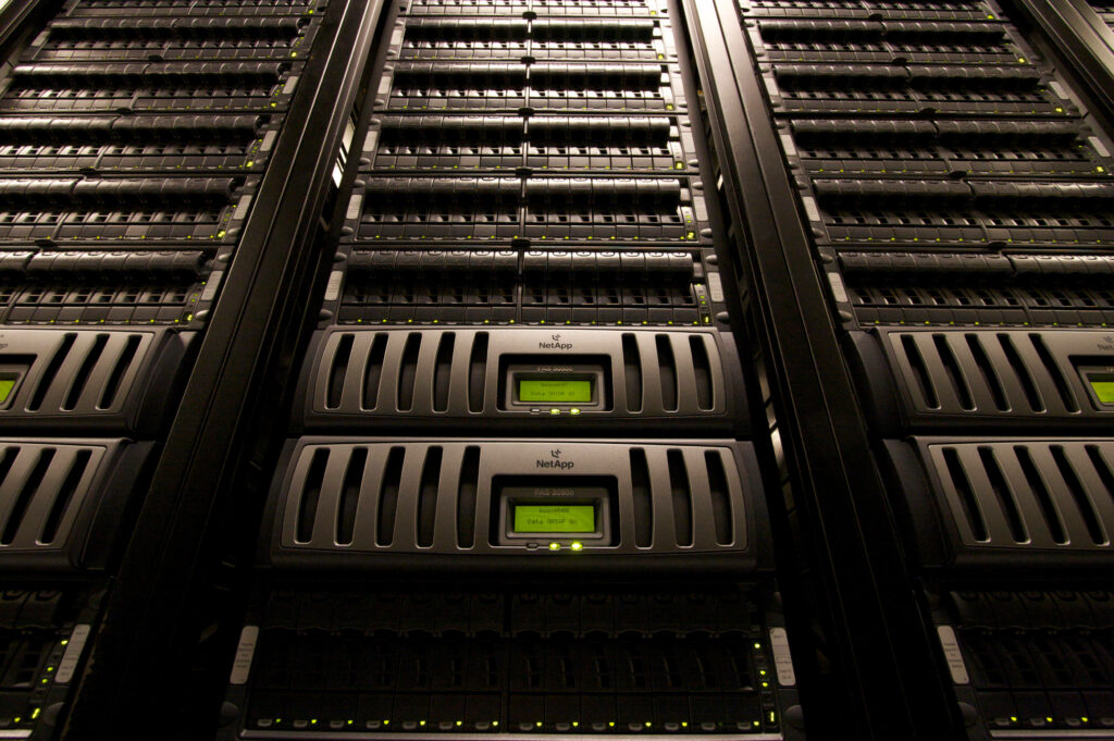 Modern data center with tall server racks and green LED lights showcasing advanced IT infrastructure Wallpaper