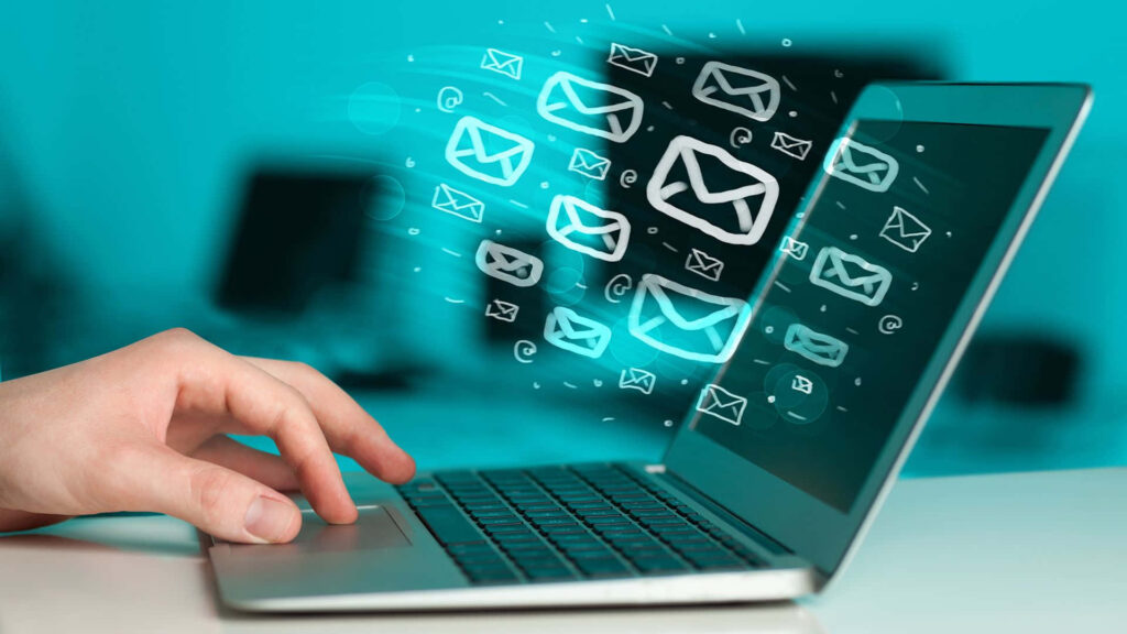 Person typing on laptop with floating email icons symbolizing digital communication connectivity Wallpaper