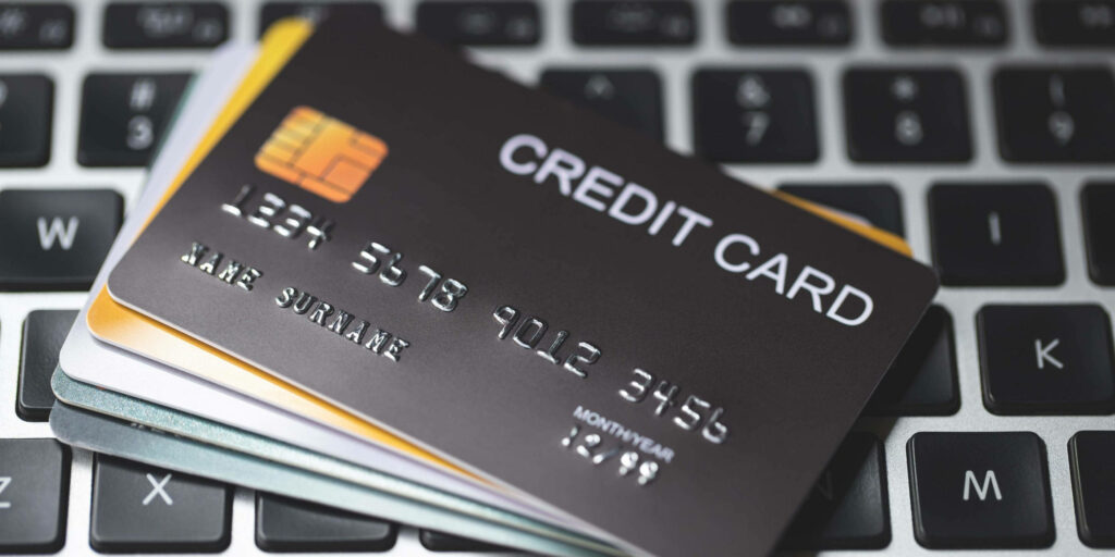 Stack of unbranded credit cards on laptop keyboard highlighting online banking and fintech concepts Wallpaper