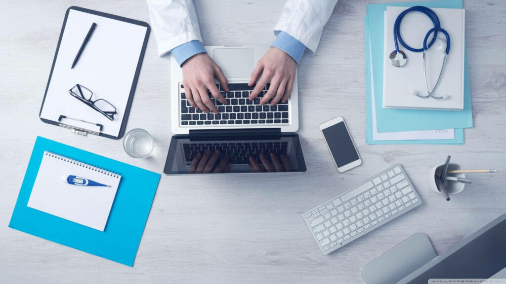 Modern doctor workspace with laptop stethoscope clipboard thermometer smartphone blue white tones Wallpaper