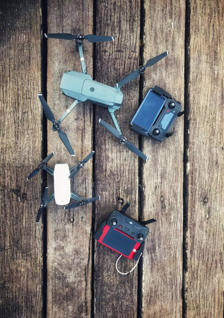 Two sleek drones with remote controllers on rustic wooden surface modern drone technology background Wallpaper