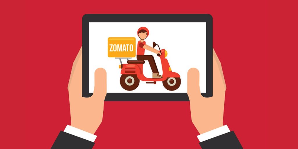 Person in formal wear holding tablet showing Zomato delivery rider on scooter red background Wallpaper