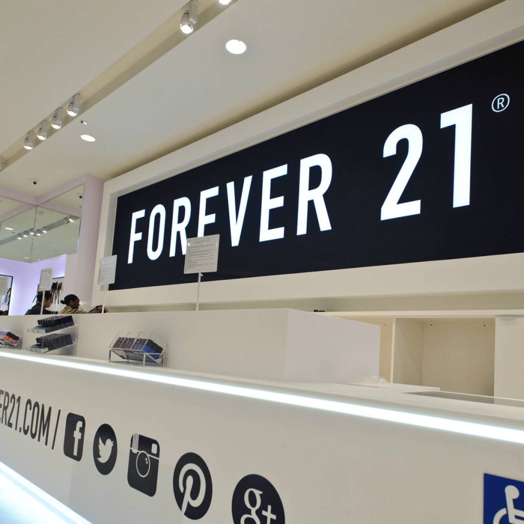 Forever 21 modern cashier counter with social media icons bright white desk and bold logo background Wallpaper