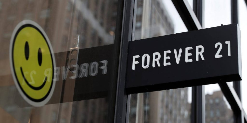 Close-up of Forever 21 storefront with black sign and yellow smiley face modern urban wallpaper