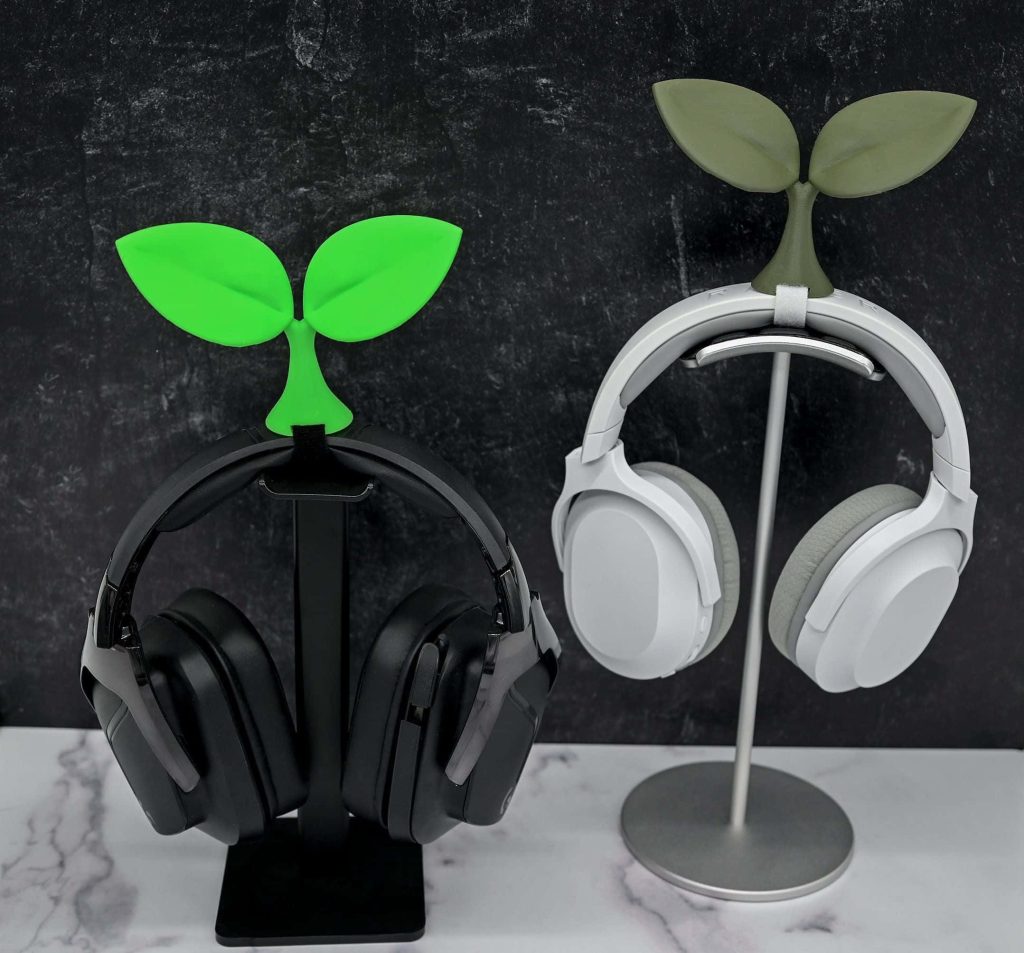 Black and white gaming headsets with sprout attachments on stands on dark marble desktop wallpaper