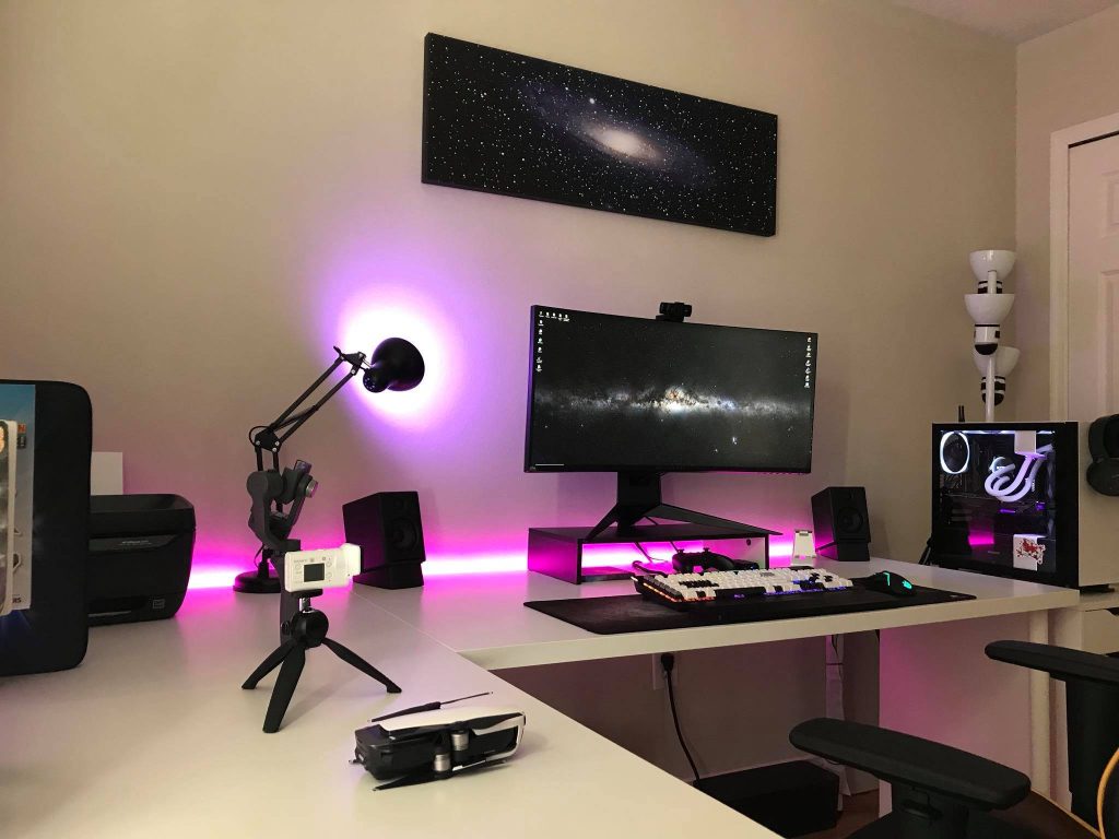 Modern gaming room with white desk ultrawide galaxy monitor pink RGB lights and space wall art Wallpaper