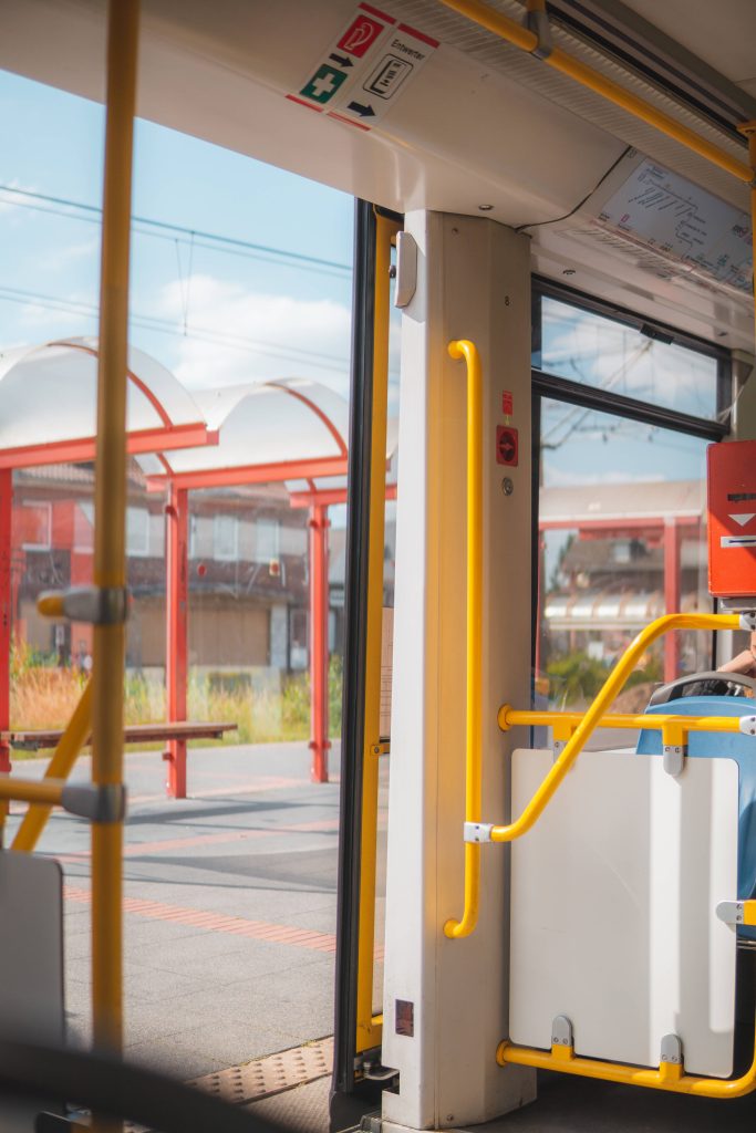 German tram interior with yellow handrails ticket validator and modern curved orange roofs view Wallpaper
