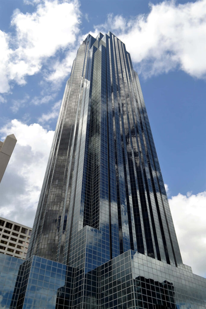 Modern glass skyscraper reflecting blue sky and clouds urban architecture wallpaper background