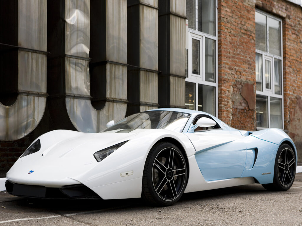White & Light Blue Marussia B1: Sleek Wallpaper with Industrial Backdrop