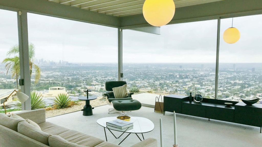 Modern living room Zoom background with mid-century Eames chair and panoramic city skyline view Wallpaper