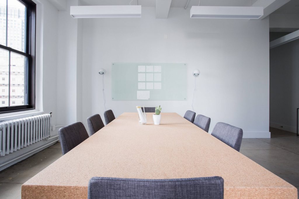 Professional Zoom background of modern assembly room with cork table grey chairs and glass board Wallpaper