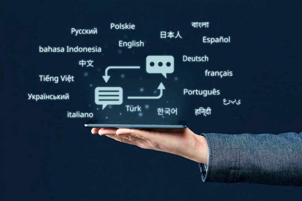 Hand holding tablet with floating multilingual language names on dark blue high-tech digital wallpaper