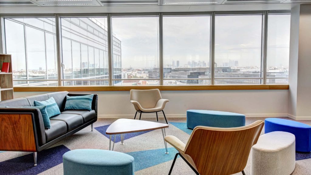 Bright modern office lounge with city view sleek furniture geometric accents ideal Zoom background Wallpaper