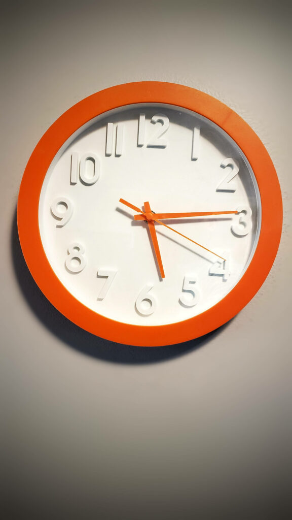 Modern wall clock with vibrant orange frame and large white 3D numbers on white background Wallpaper