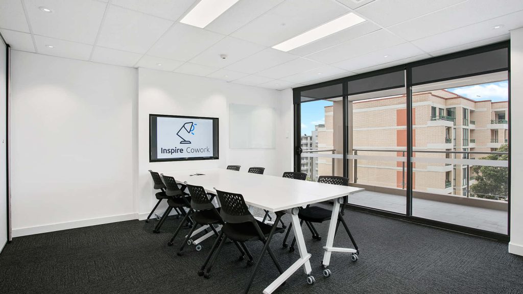 Modern Inspire Cowork meeting room with white table black chairs and bright natural light Wallpaper