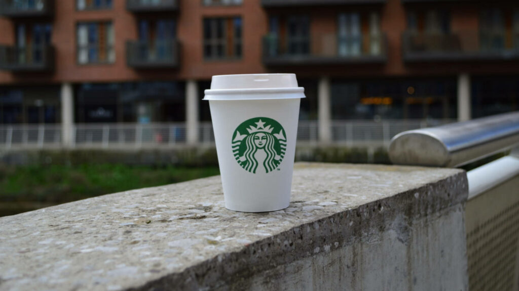 Starbucks coffee cup on concrete urban background stylish modern wallpaper for coffee lovers