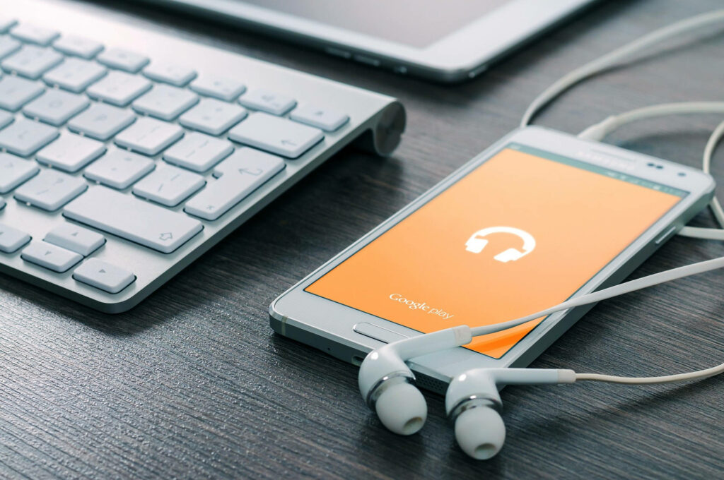 Modern Tech Wallpaper: Smartphone, Earphones & Tablet on Wooden Desk