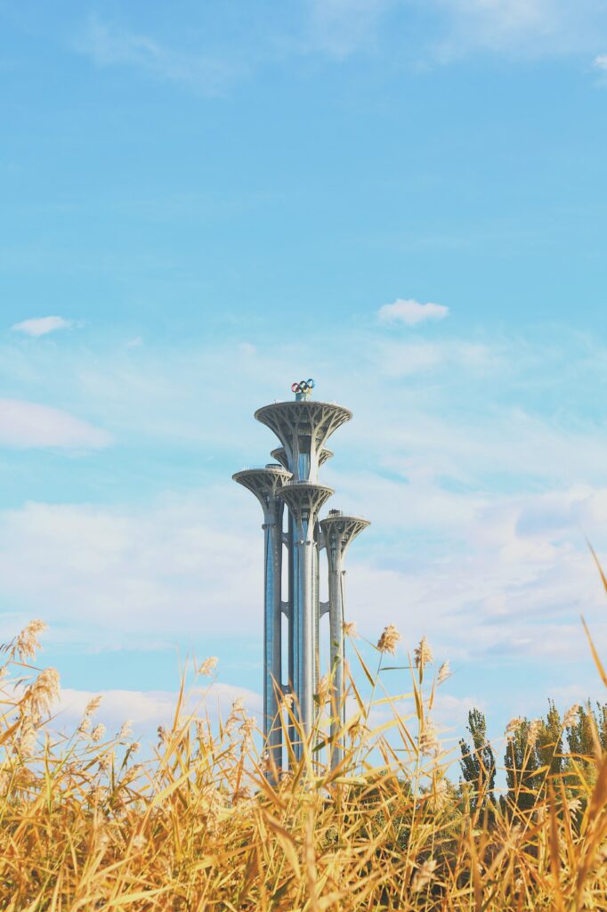 Striking Modern Tower Wallpaper Against Clear Blue Sky & Golden Plants