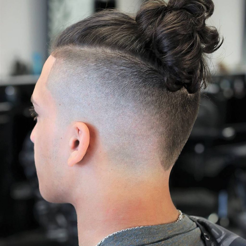 Stylish men’s undercut with skin fade and top knot side-profile wallpaper background