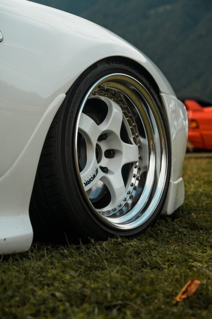Close-Up of Sleek White Car Wheel Amid Nature's Backdrop Wallpaper