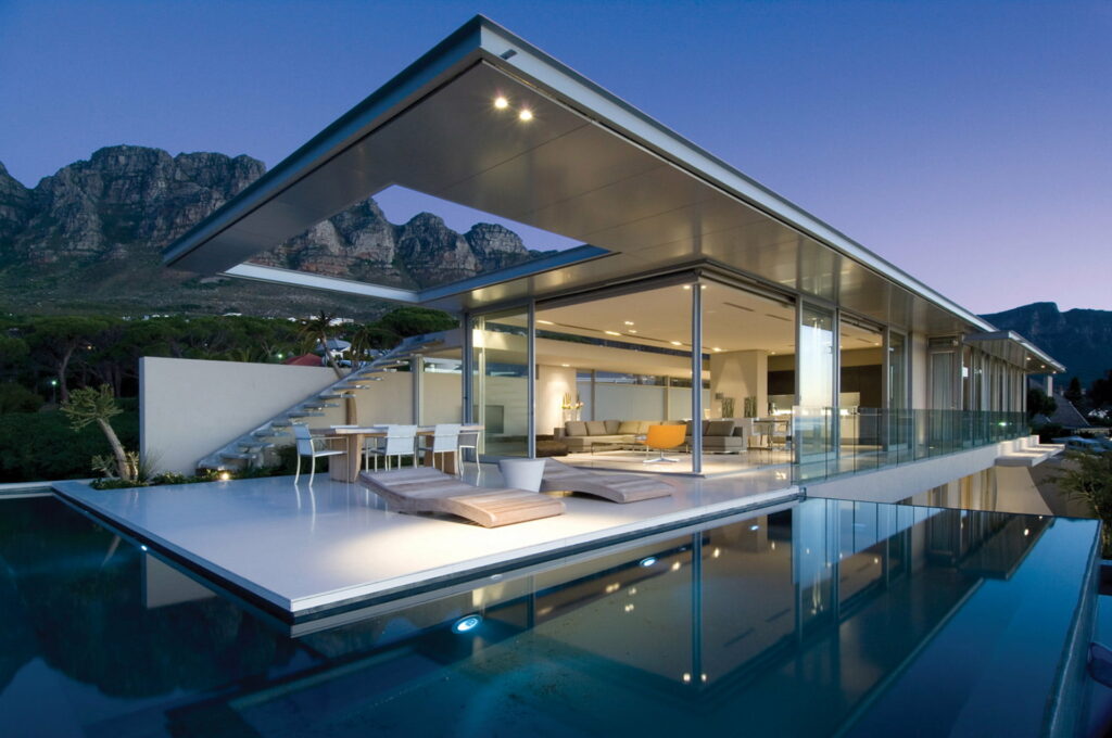 Serene Cape Town villa with infinity pool and glass walls against Twelve Apostles mountains at dusk Wallpaper