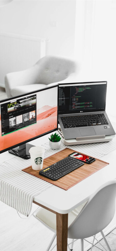 Tech-Ready Workspace: Orderly iPhone Desk with Computer, Laptop, Keyboard, Smartphone, and Starbucks Cup Wallpaper