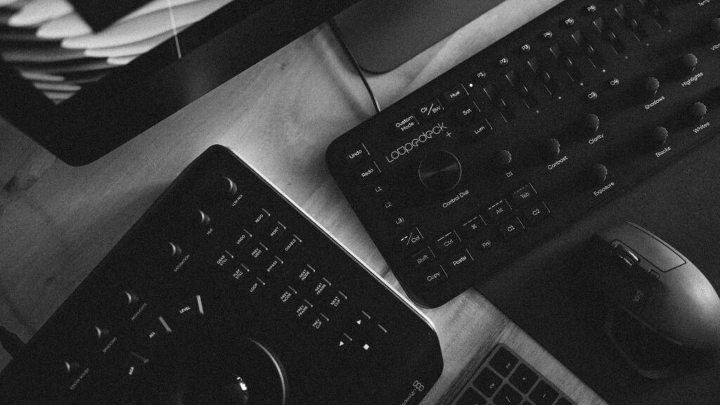 Modern desktop workspace with Logitech accessories and editing consoles black and white wallpaper