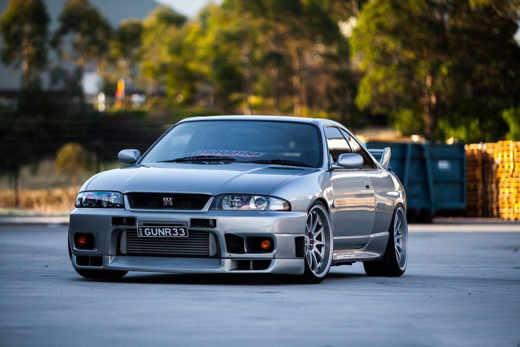 Modified silver Nissan Skyline GT-R R33 with custom wheels and front intercooler in daylight Wallpaper