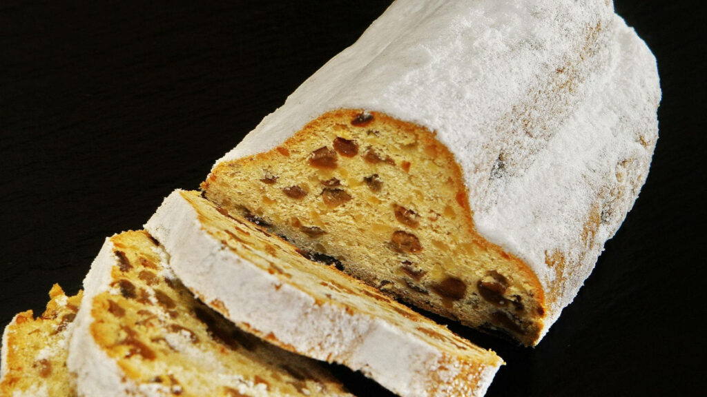 High definition sweet bread with powdered sugar raisins and dried fruits on dark background wallpaper