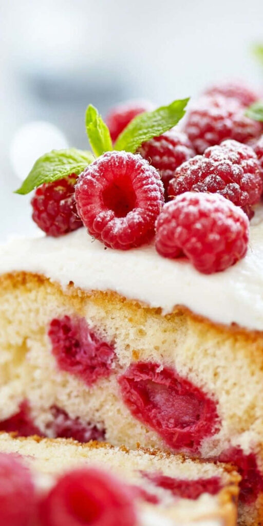 Close-up of moist raspberry cake slice with fresh raspberries frosting and mint on pastel background Wallpaper