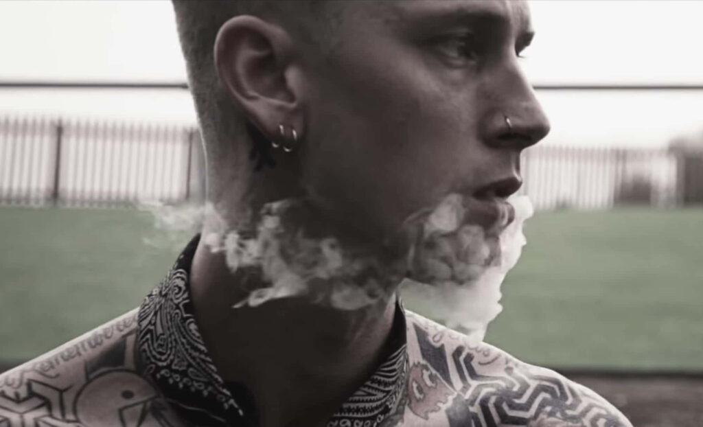 Edgy Monochromatic Wallpaper: Machine Gun Kelly's Dramatic Tattooed Look