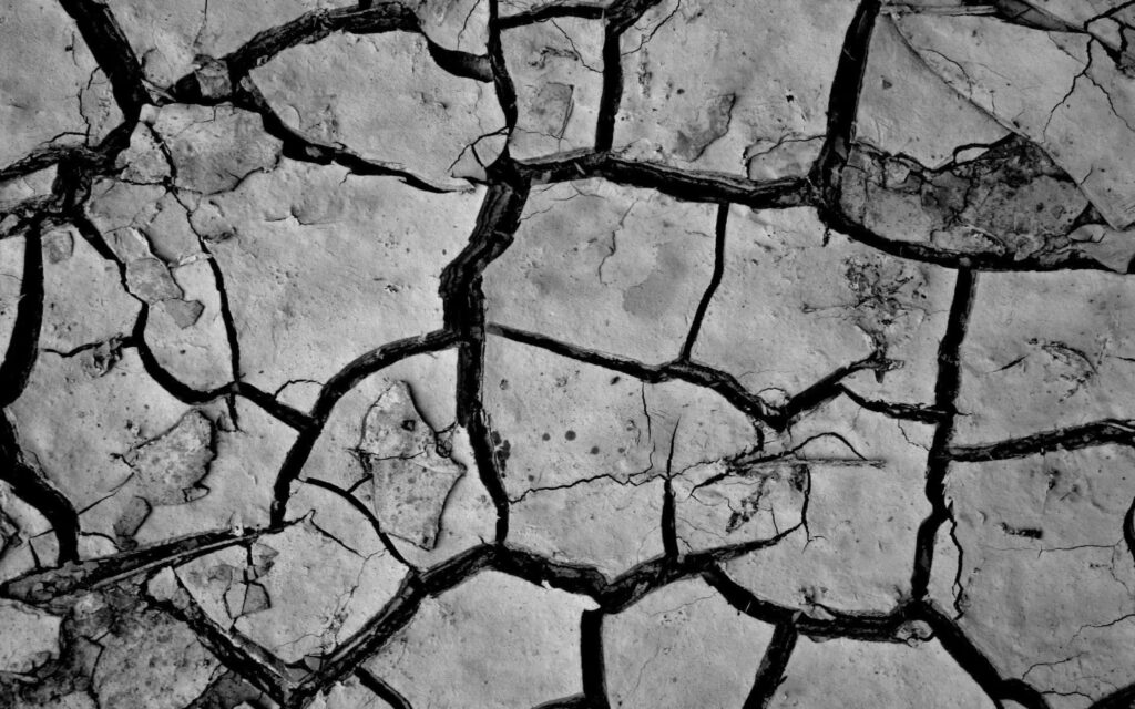 Rugged Grey Ground Wallpaper: Monochromatic Cracked Texture Background