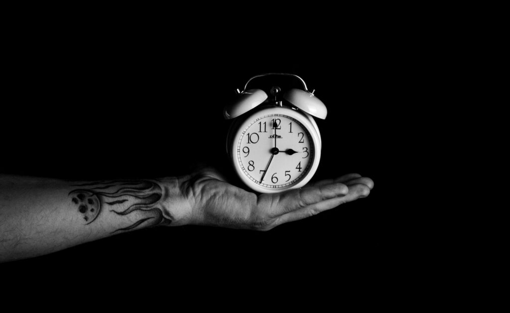 Monochrome Alarm Clock in Hand: Black and White Wallpaper Design