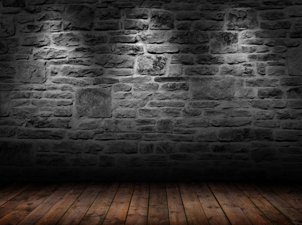 Monochromatic Brilliance: Illuminated Dark Stone Wall with Top Light Sources - Background Wallpaper