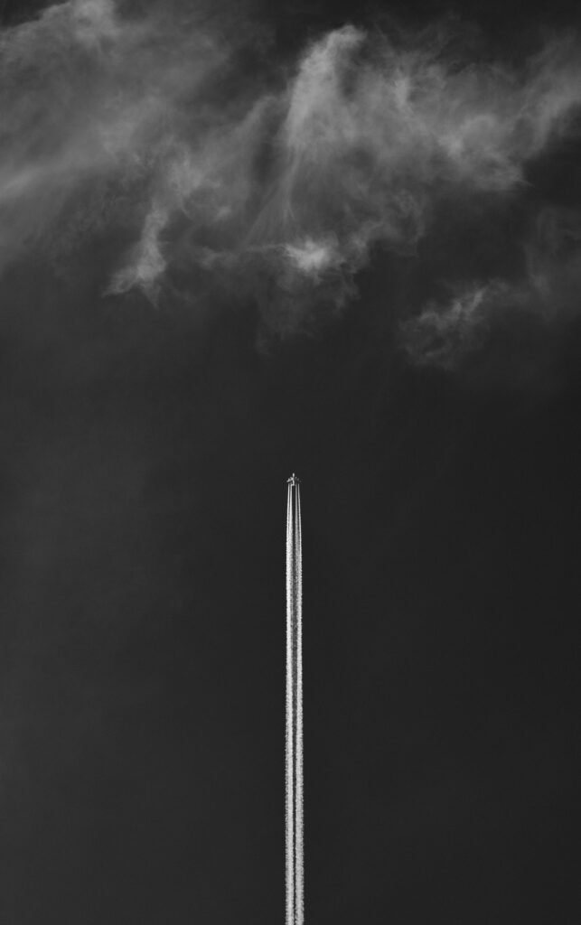 Monochrome Wallpaper: Plane Takeoff with Contrail & Dramatic Sky