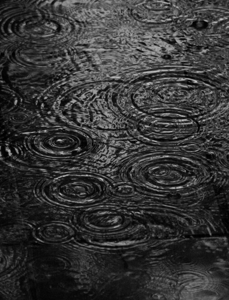 Monochrome wallpaper of raindrop ripples on water in black and gray minimalist natural design