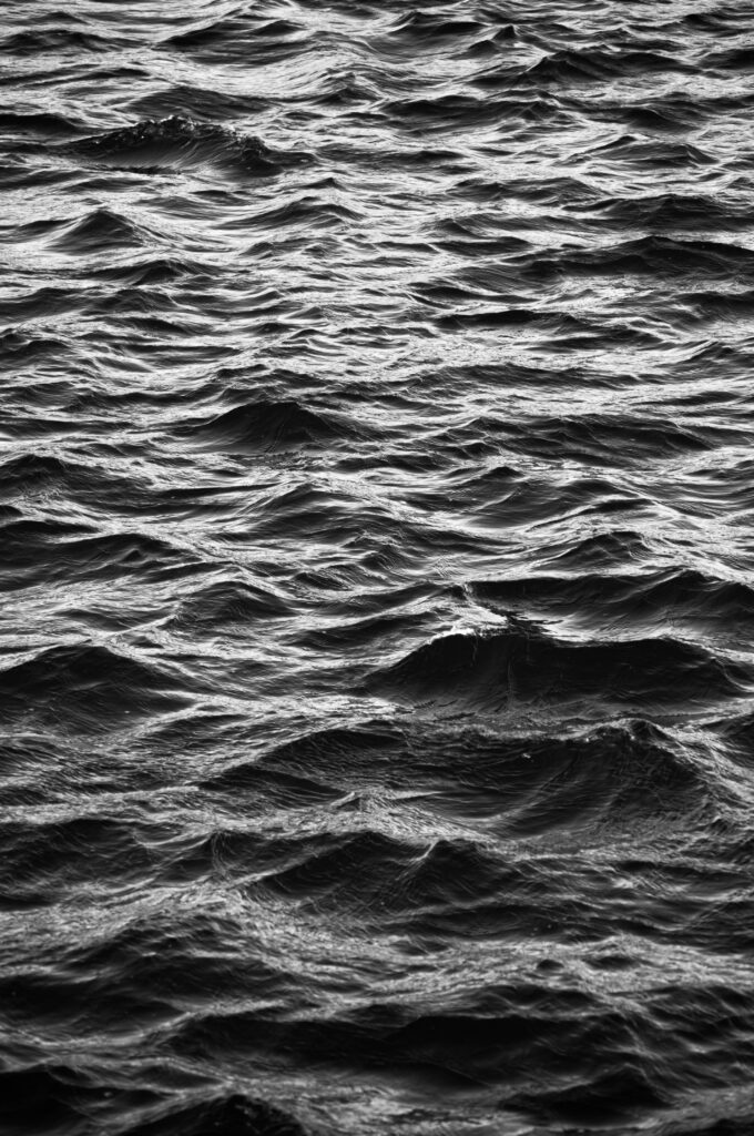 Black and white rippling water surface wallpaper with gentle waves and reflective texture background
