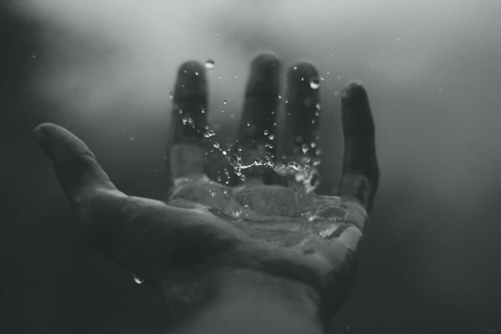 Monochrome Hand Catching Raindrops - Artistic Water Motion Wallpaper