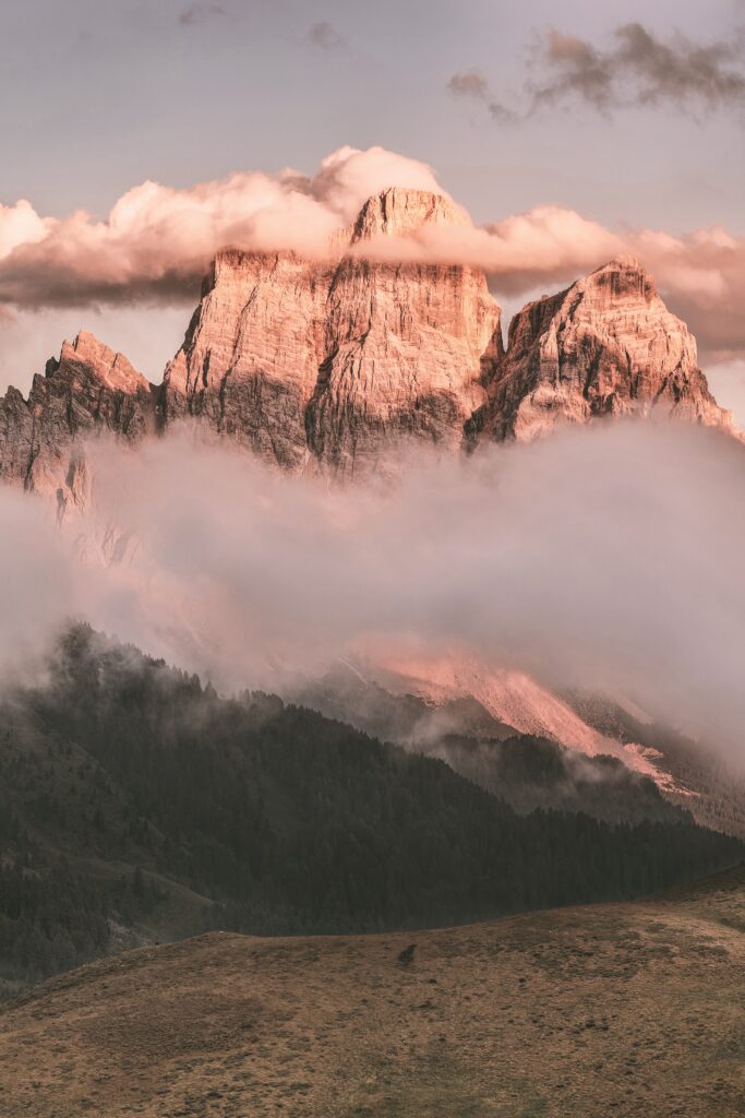 Monte Pelmo mountain in the Dolomites Italy with pink light clouds and forested hills wallpaper