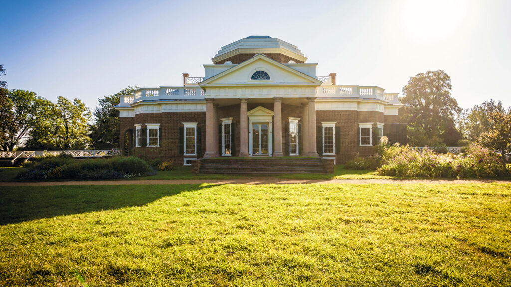 Monticello neoclassical mansion bright sunlight red brick white columns green gardens blue sky Wallpaper